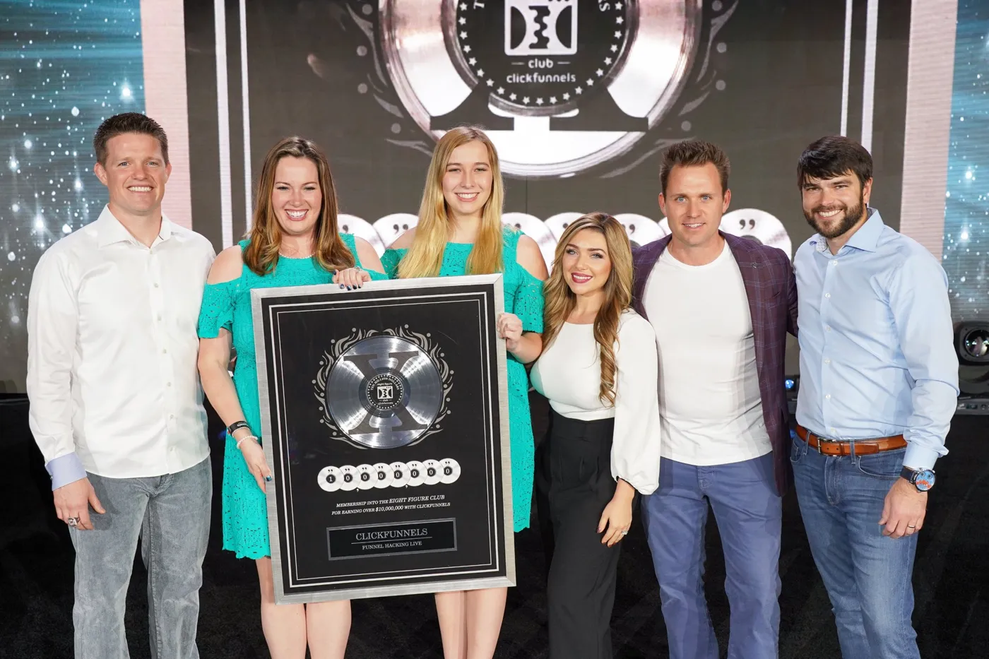 Stephanie and Bryan Dulaney on stage with clients receiving a Two Comma Club X award